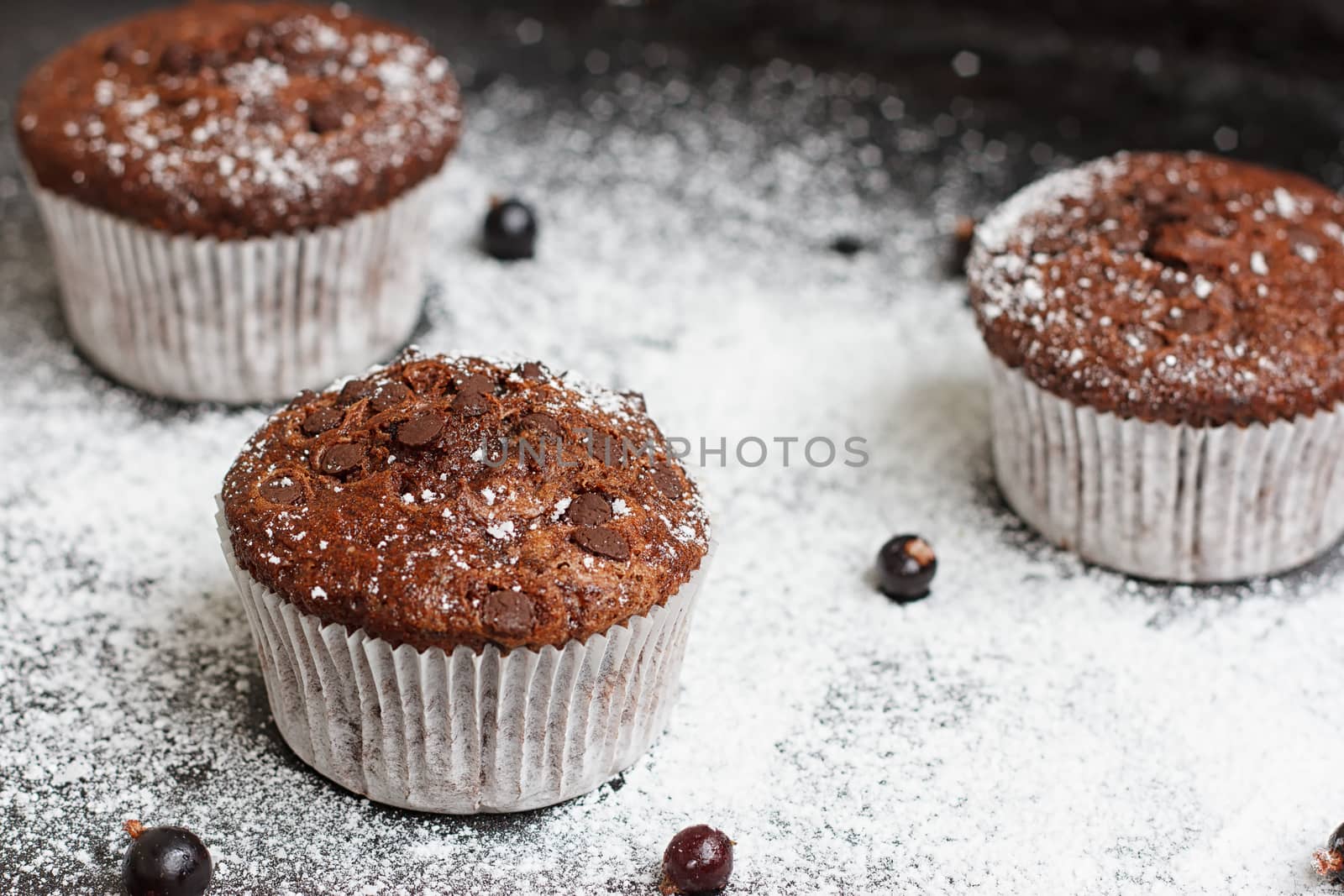 Chocolate cake on a black table with powdered sugar