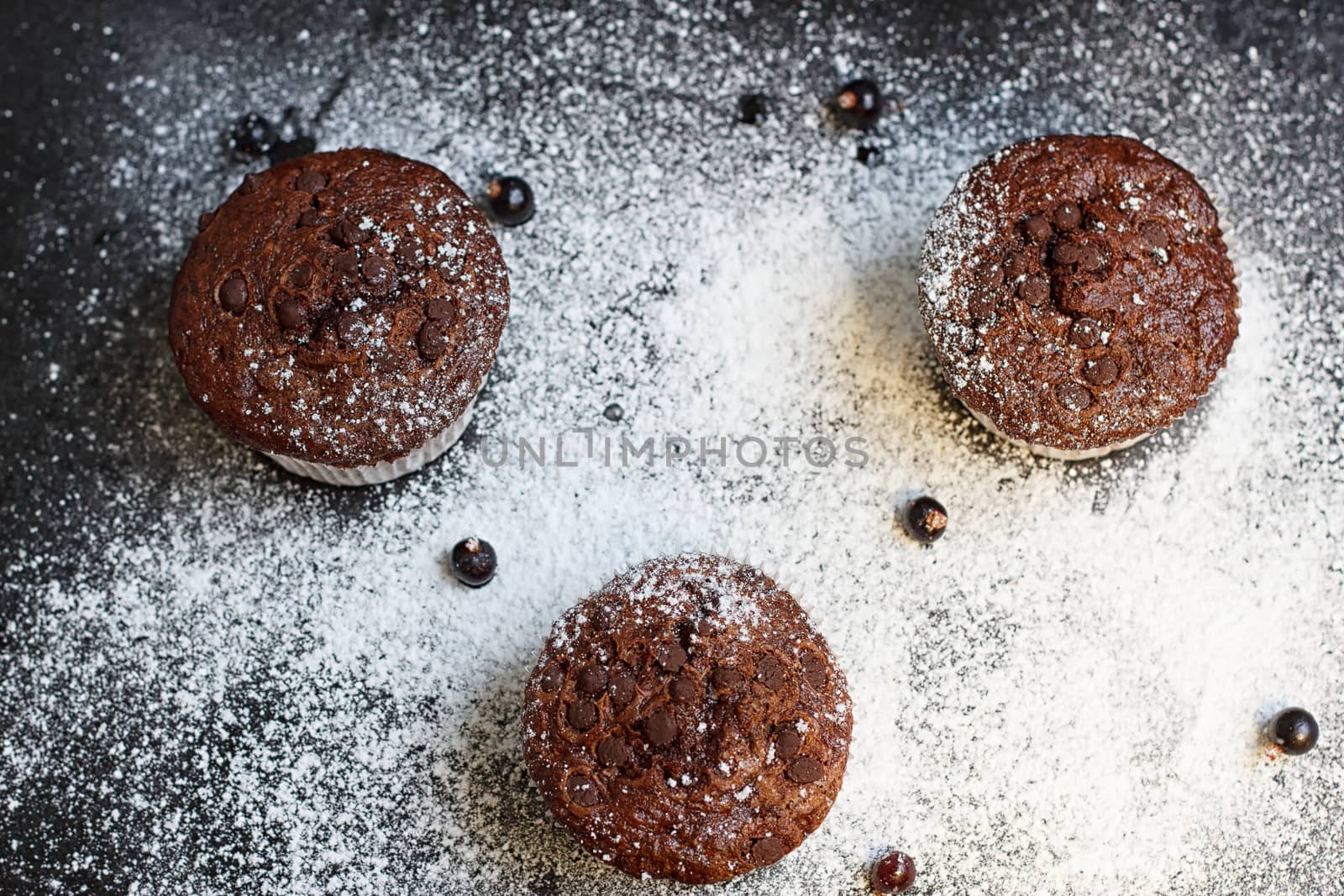 Chocolate cake on a black table with powdered sugar