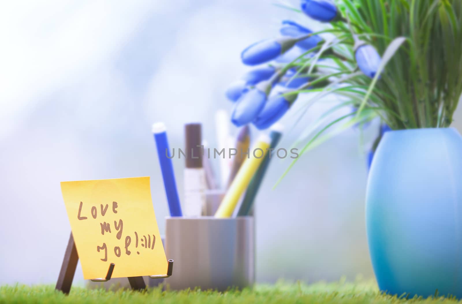 Adhesive note with Love my job text at green office by Novic