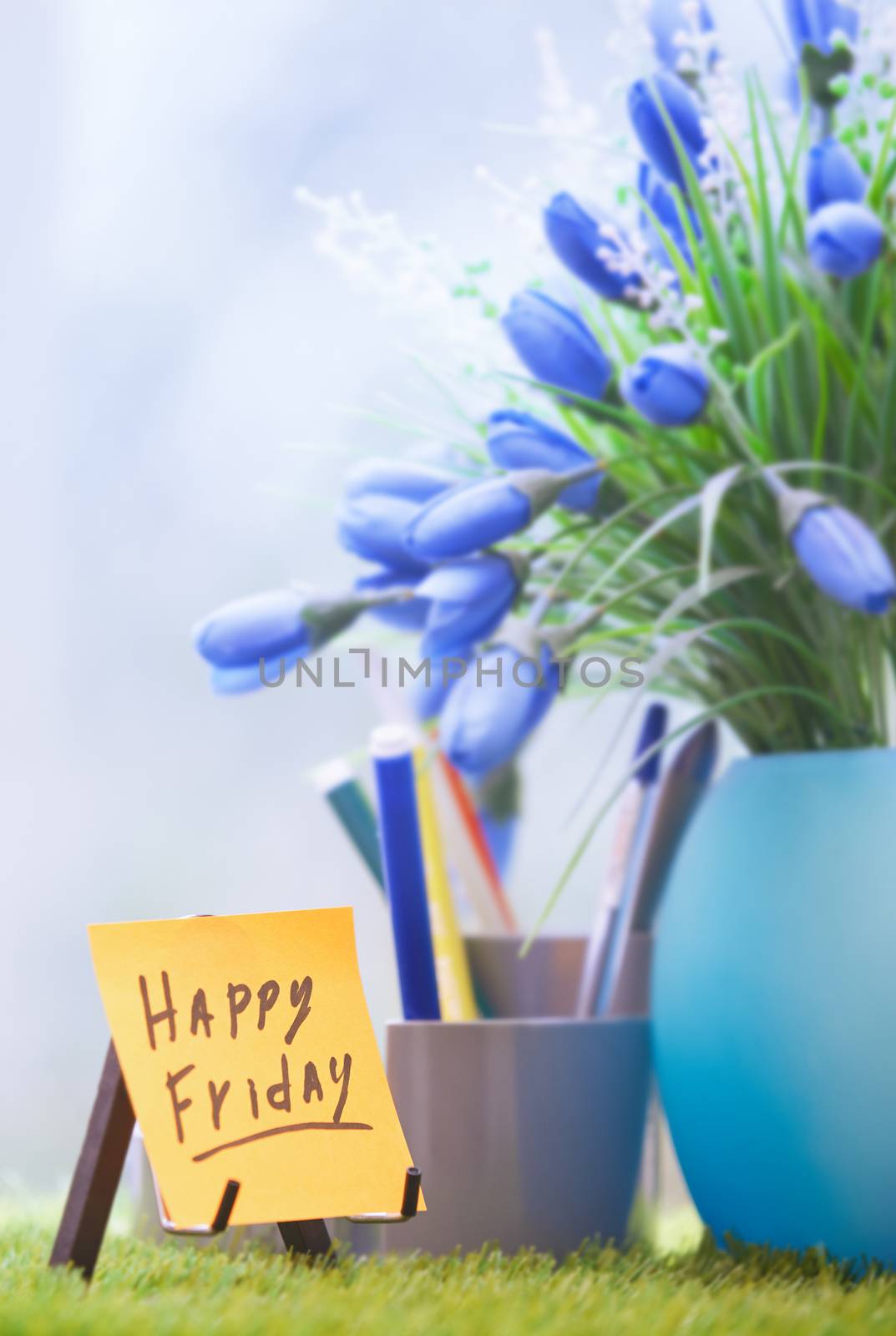 Adhesive note with Happy Friday text  at green office by Novic