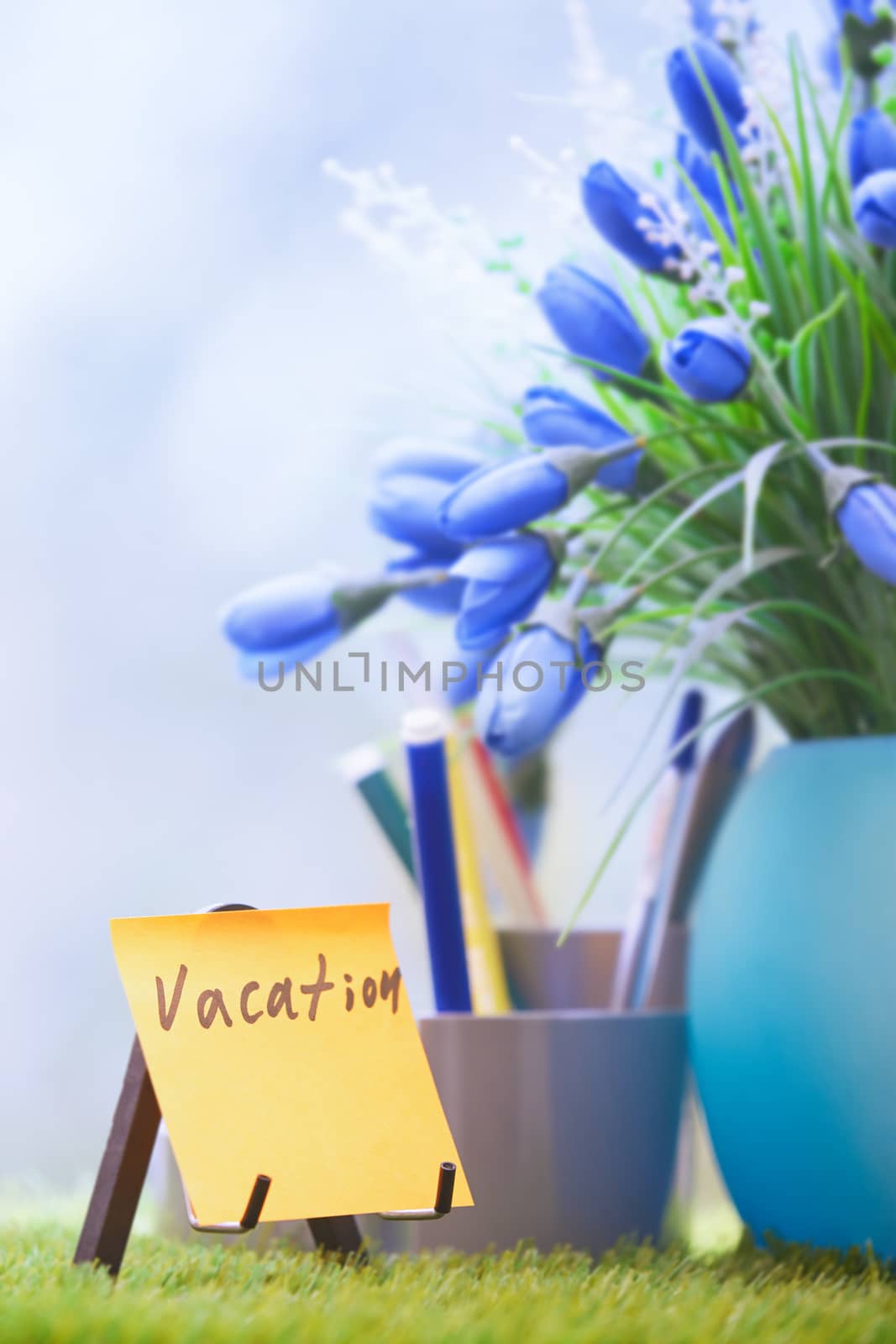 Adhesive note with Vacation text at green office