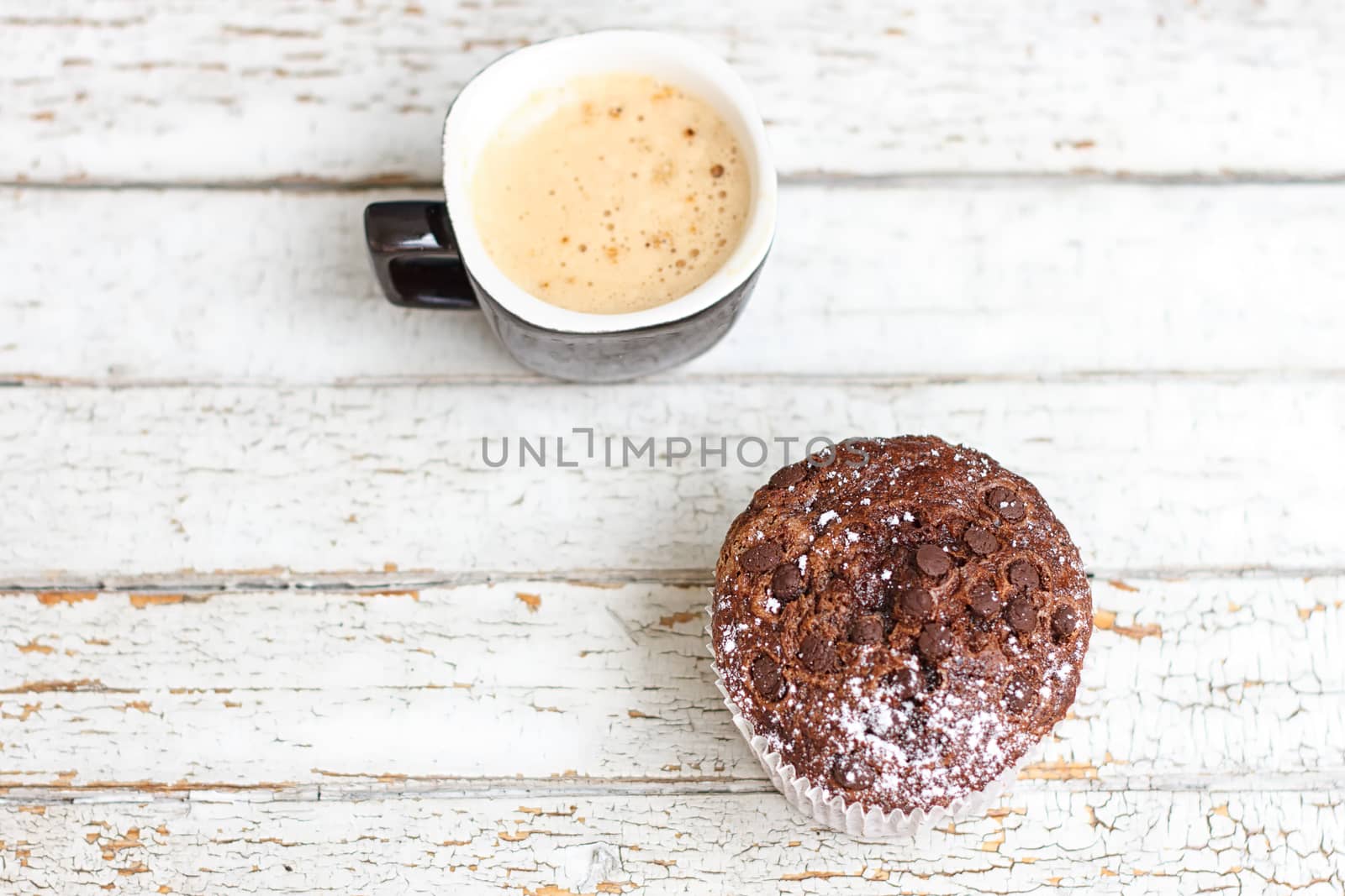 chocolate muffin and cup of coffee on the white wooden background