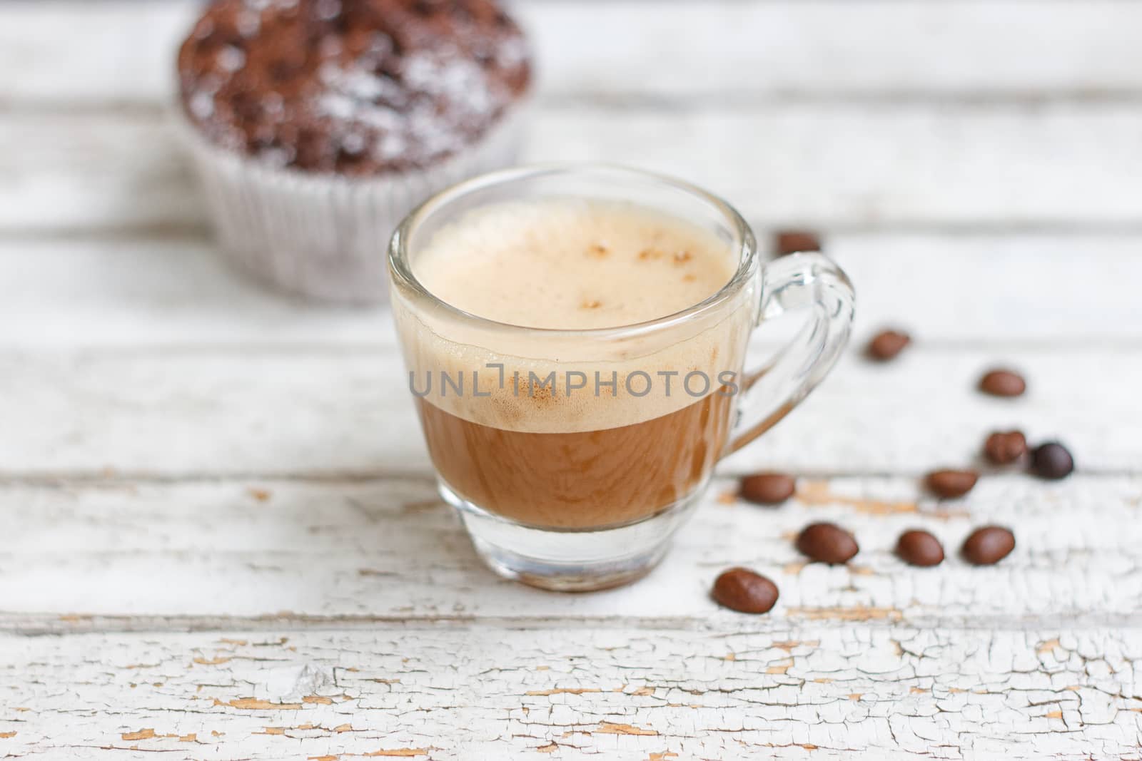 chocolate muffin and cup of coffee on the white wooden background