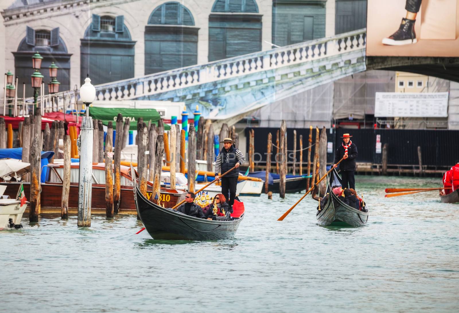 VENICE - NOVEMBER 22: Gondolas with tourists on November 22, 2015 in Venice, Italy. The gondola is a traditional, flat-bottomed Venetian rowing boat, well suited to the conditions of the Venetian lagoon. 