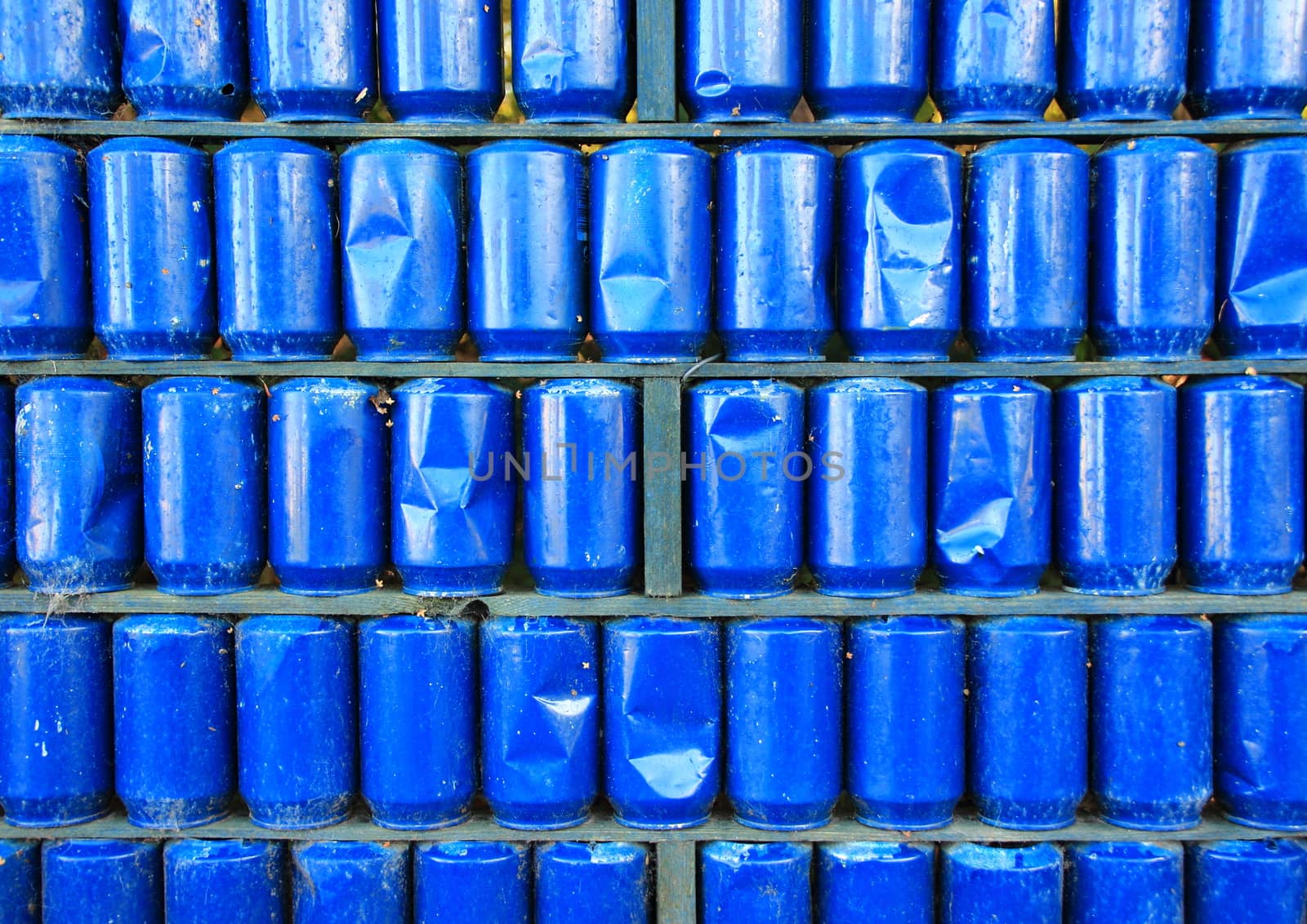 Wall of blue painted used metal cans background