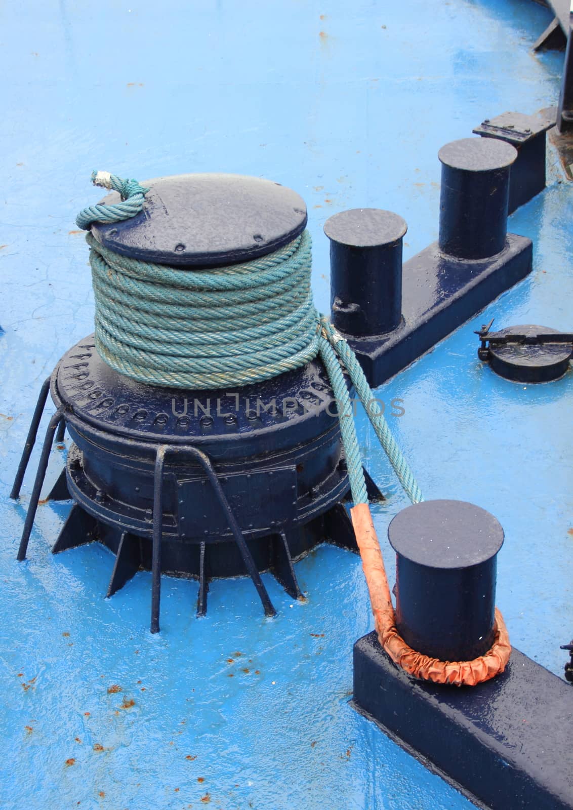 Anchor winch with rope on blue ship deck