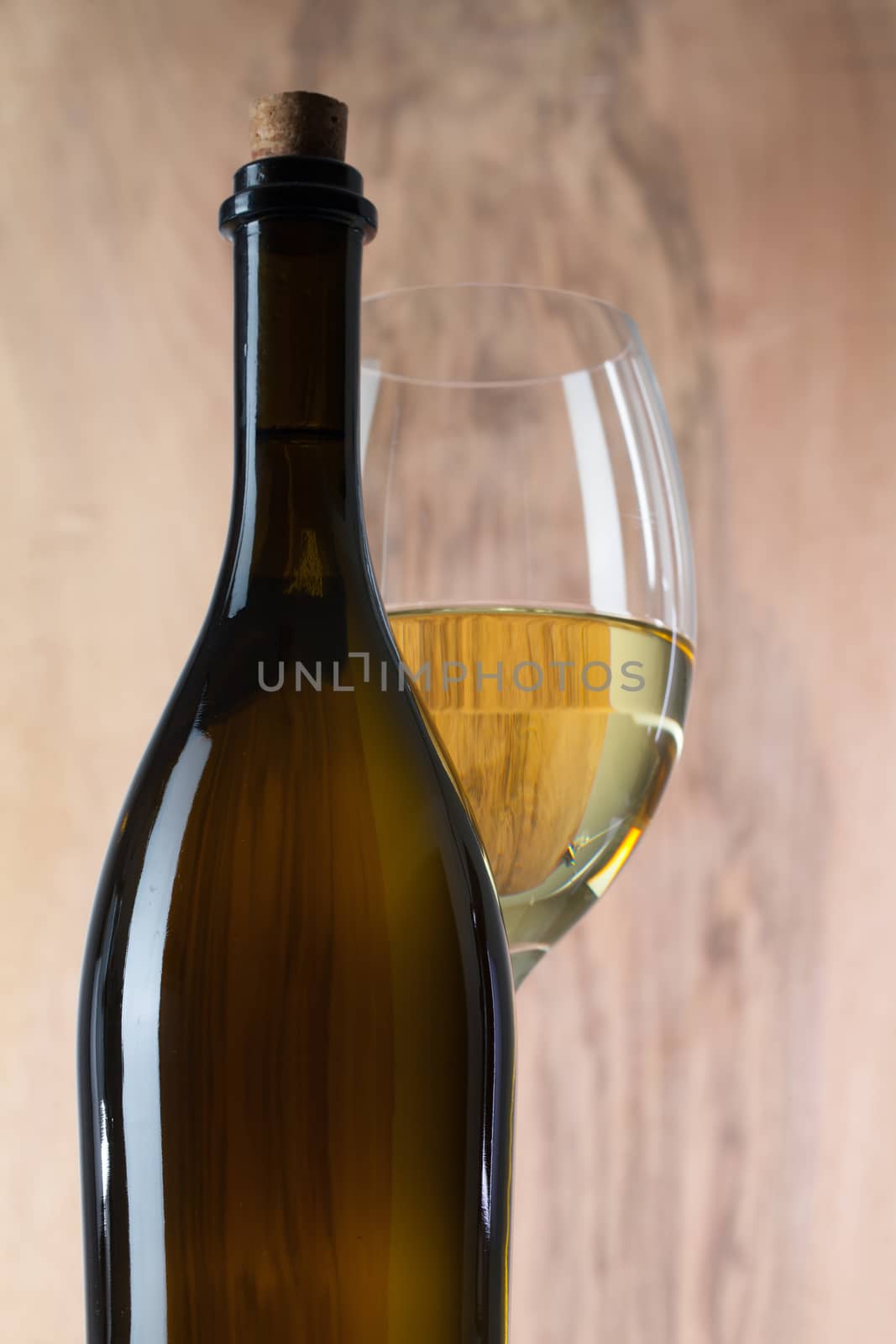 Detail of glass and bottle of wine by CaptureLight