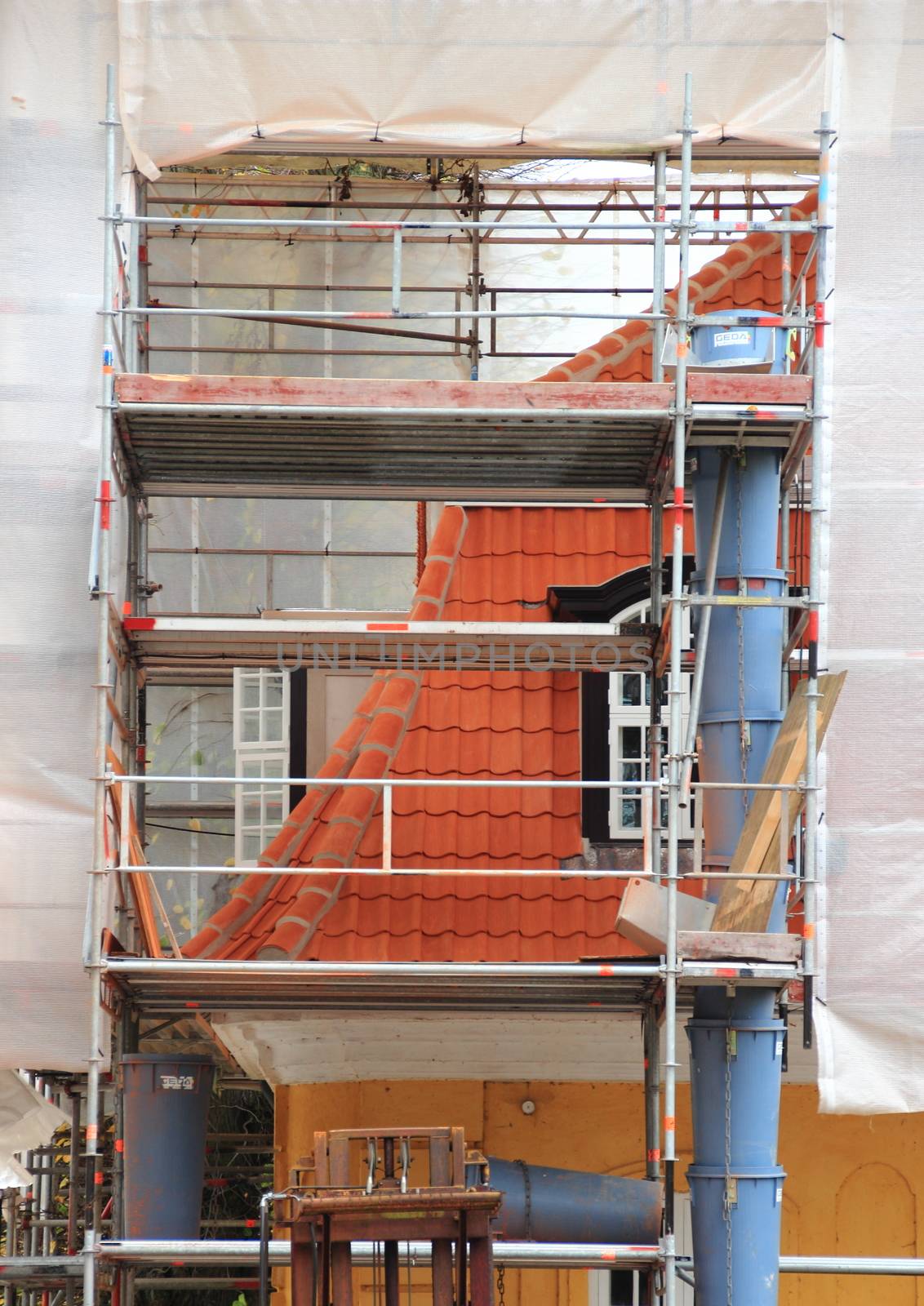Old house under repair with scaffold and tarpaulin