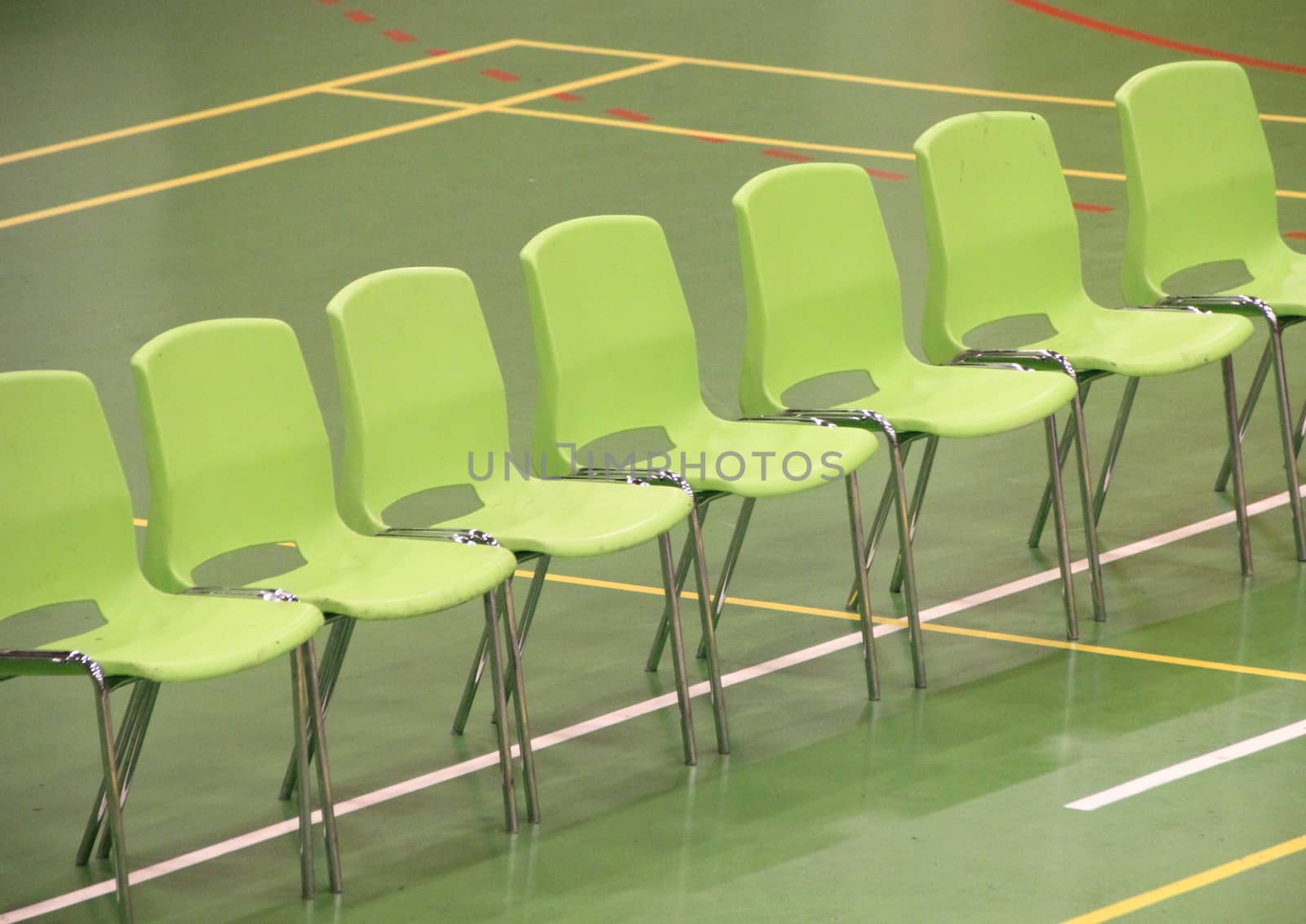 Line of green chairs in sports hall