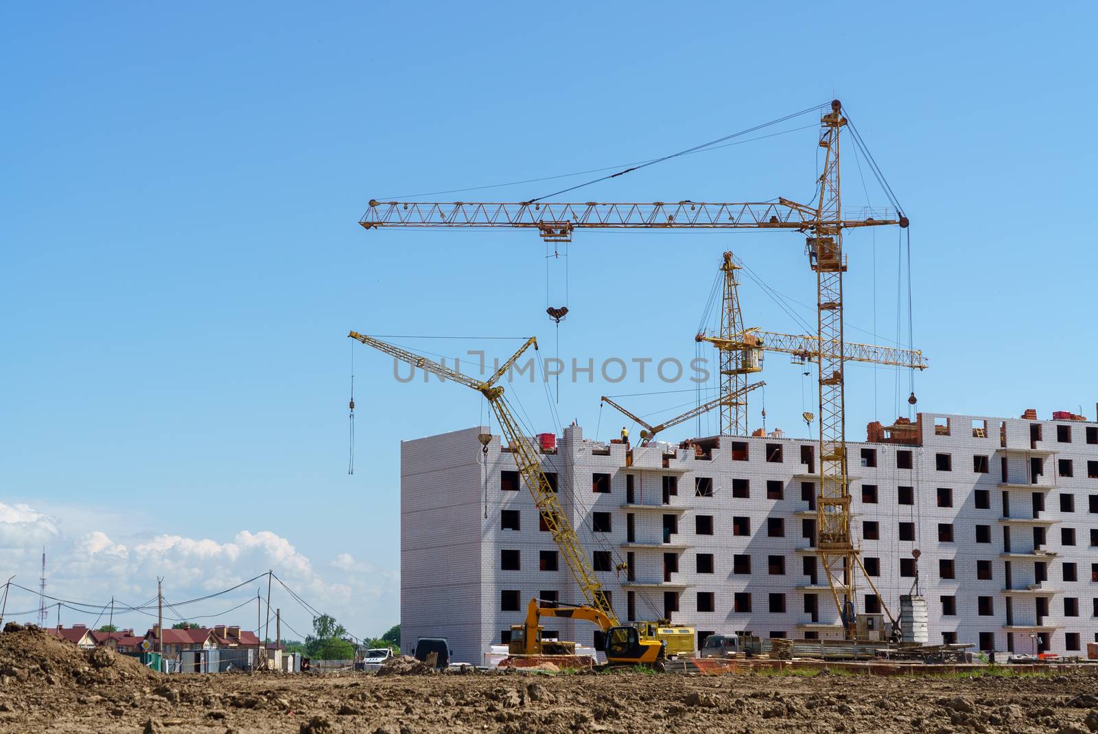 The construction of a multistory building. Construction cranes are on the building site