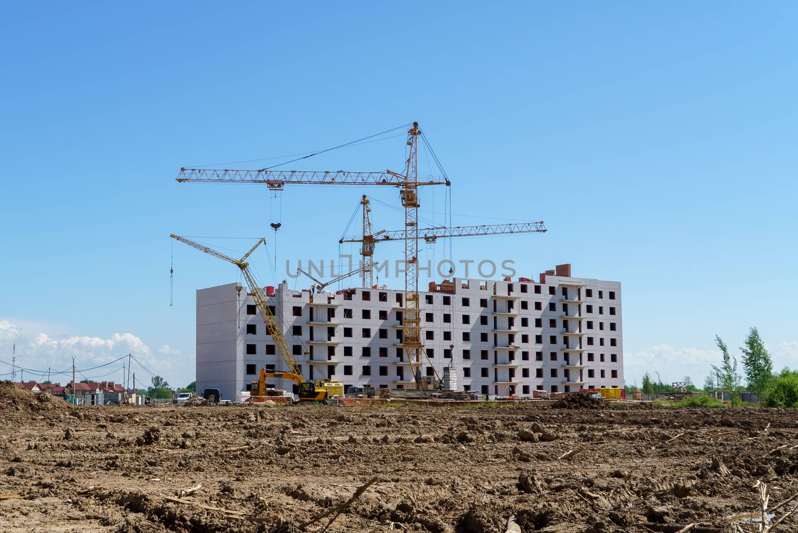 The construction of a multistory building. Construction cranes are on the building site