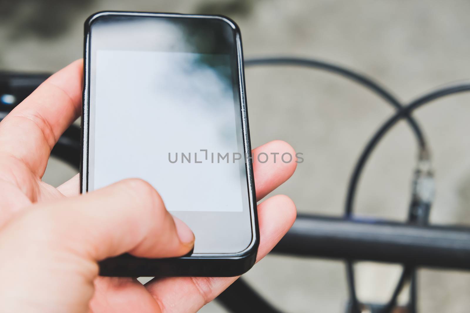 Close up image of man hand with bicycle texting on mobile phone