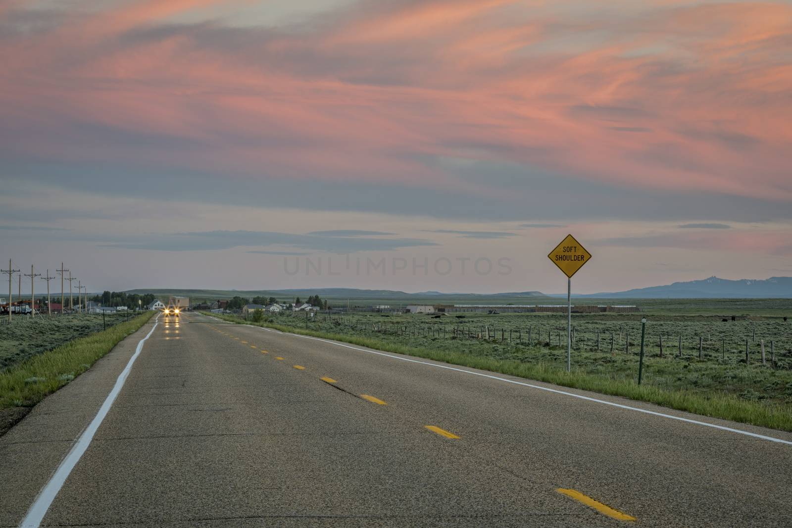 highway at dusk with pink sky near Cowdrey, North Park, Colorado