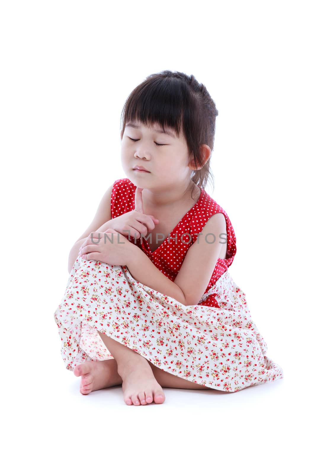 Adorable asian girl thoughtful and sitting on floor with closed eyes. Isolated on white background. conceptual about imagination of child. Studio shot.