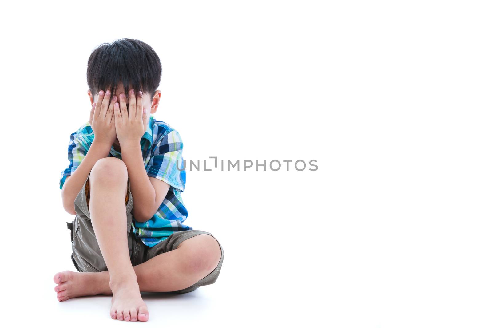 Full body. Little sad boy covered his face with hands. Isolated on white background. Negative human emotions. Conceptual about children who lack warmth and affection. Free form copy space.