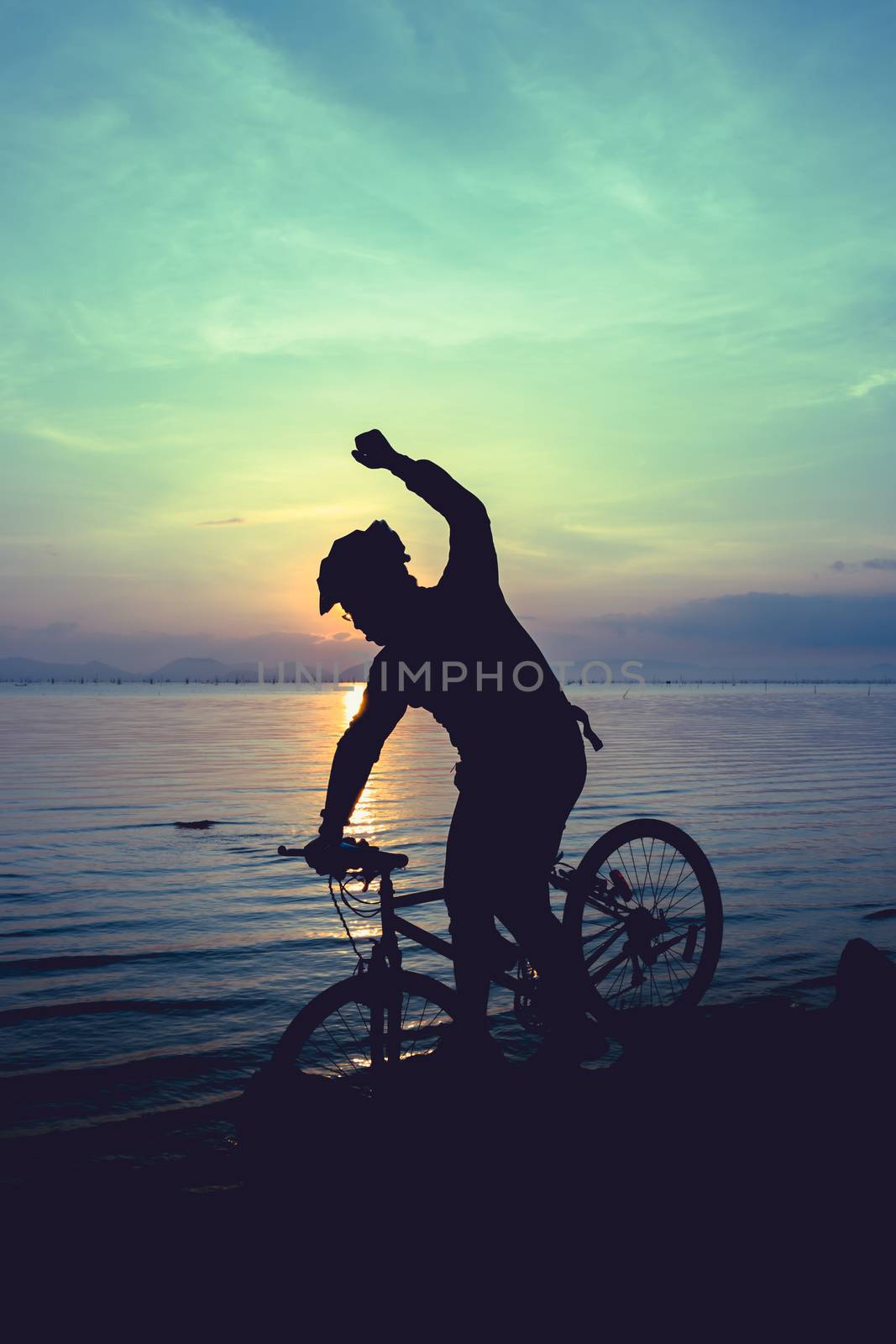 Healthy lifestyle. Silhouette of bicyclist riding the bike at se by kdshutterman