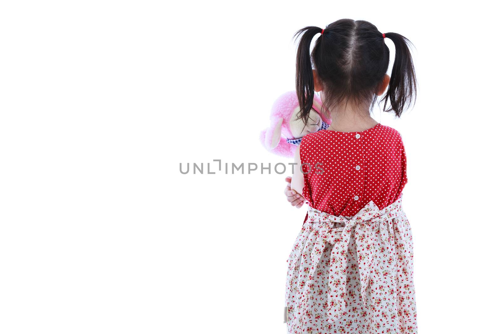 Lonely child with doll sad gesture. Back view. Isolated on white. Negative human emotion.  Free form copy space. Studio shot.