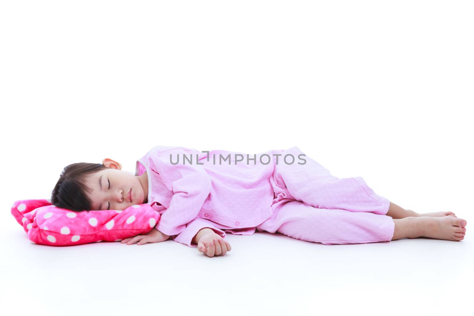 Full body. Healthy children concept. Little asian child sleeping peacefully. Adorable girl in pink pajamas taking a nap. Isolated on white background.