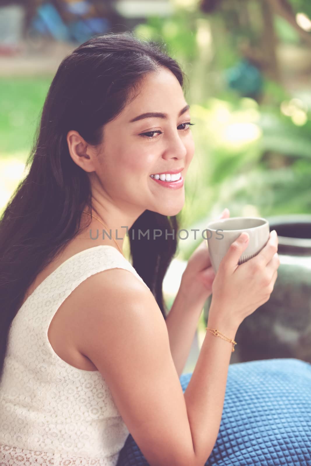 Lifestyle of beautiful asian woman enjoys fresh coffee in the morning at home. Happy time of city life. Vintage tone.