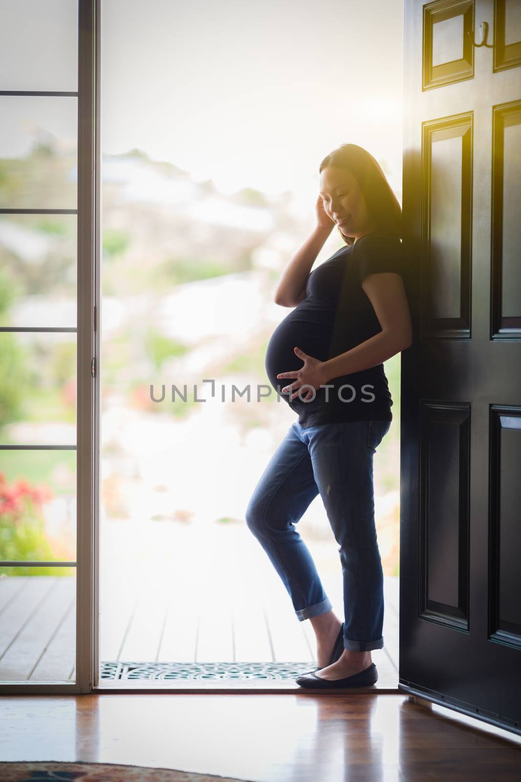 Happy Chinese Pregnant Woman Standing in Doorway.