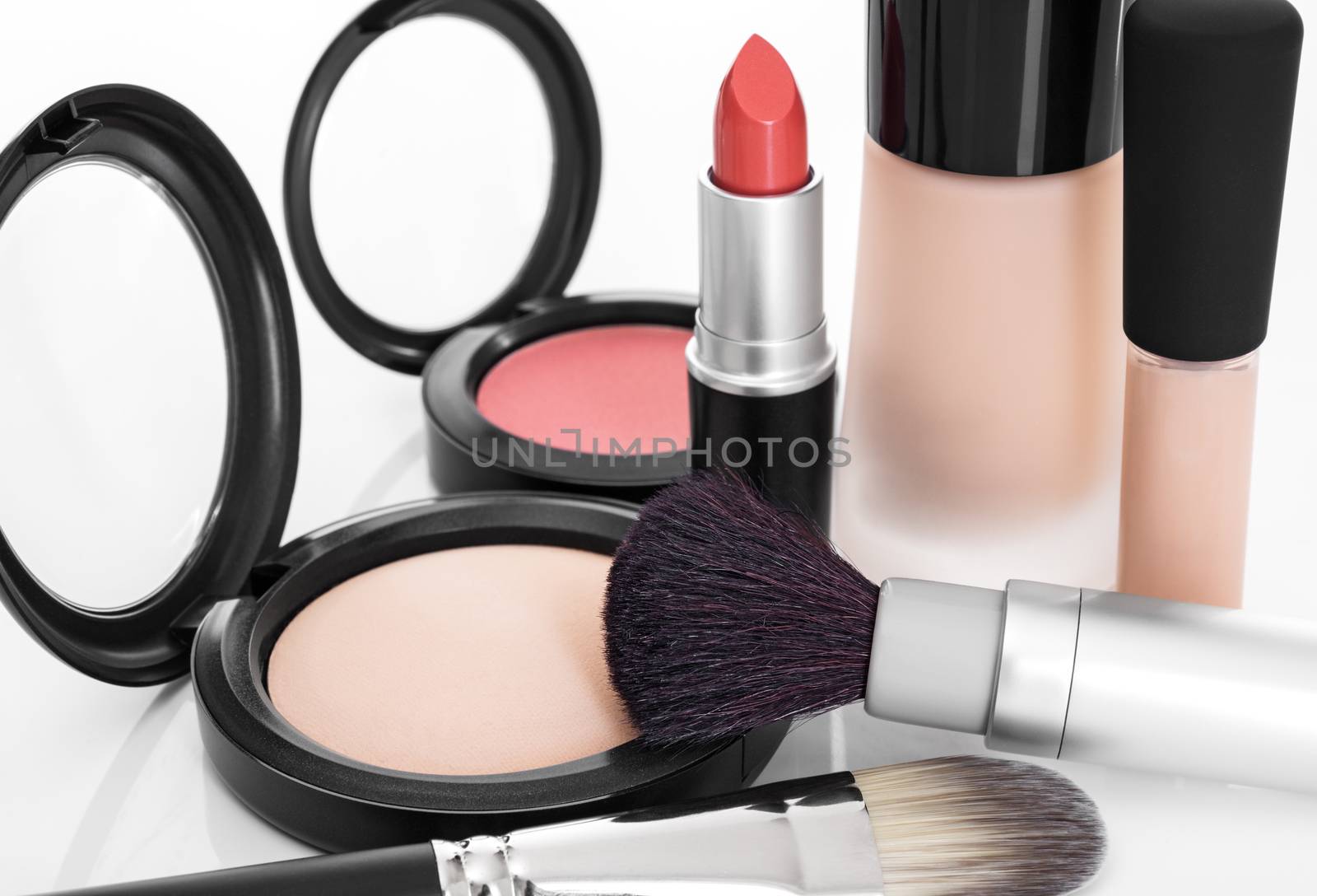 Elegant makeup collection. Foundation, concealer, face powder, blush, lipstick, brushes.