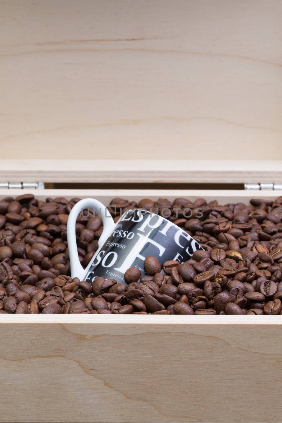 Coffee beans and coffee cup in an open wooden box