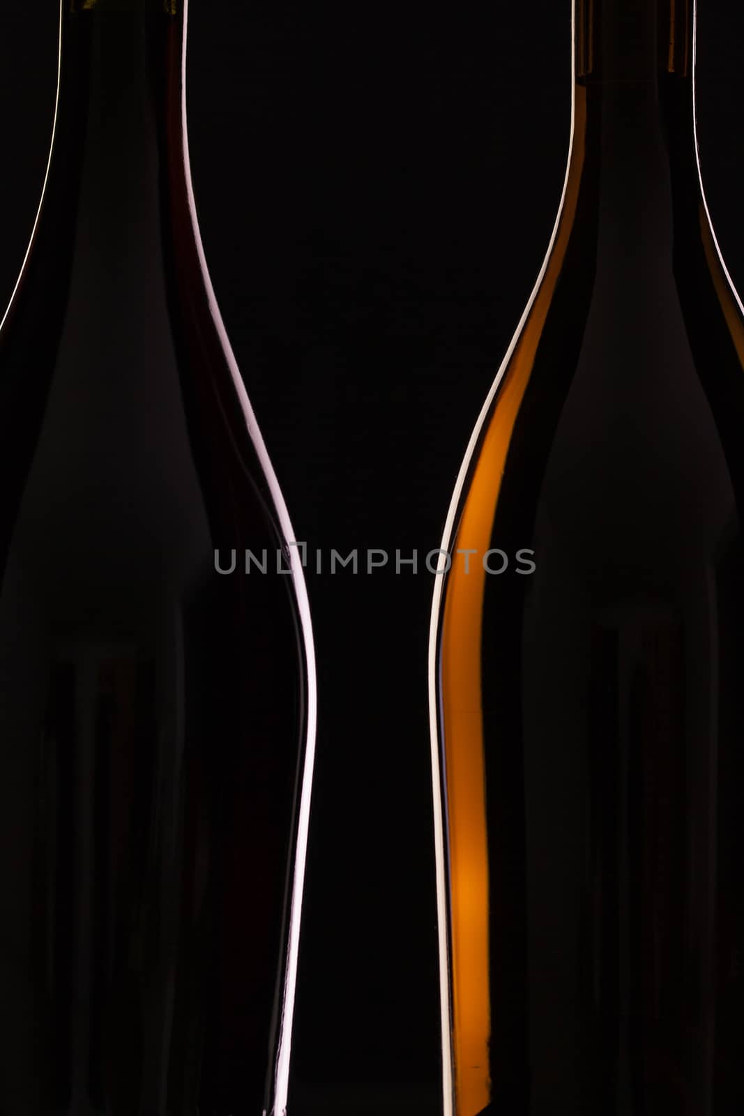 Two different bottles of wine on the black background