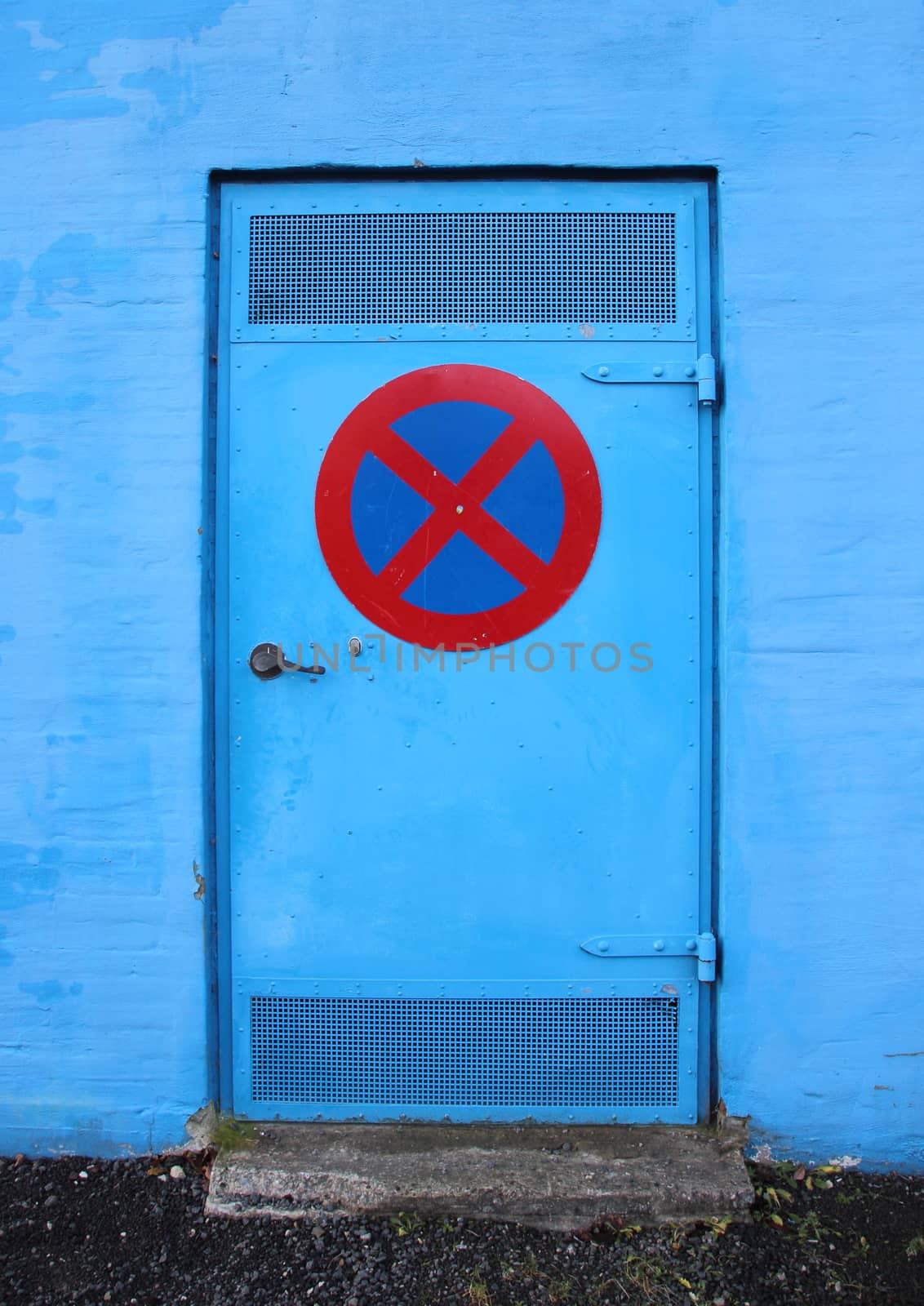Blue Metal Door on Blue Brick Wall with No Stop Sign