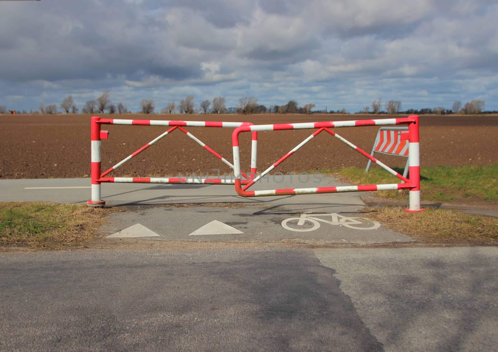 Bicycle Safety Barrier in Stripes and Bike Sign on Rural Road by HoleInTheBox
