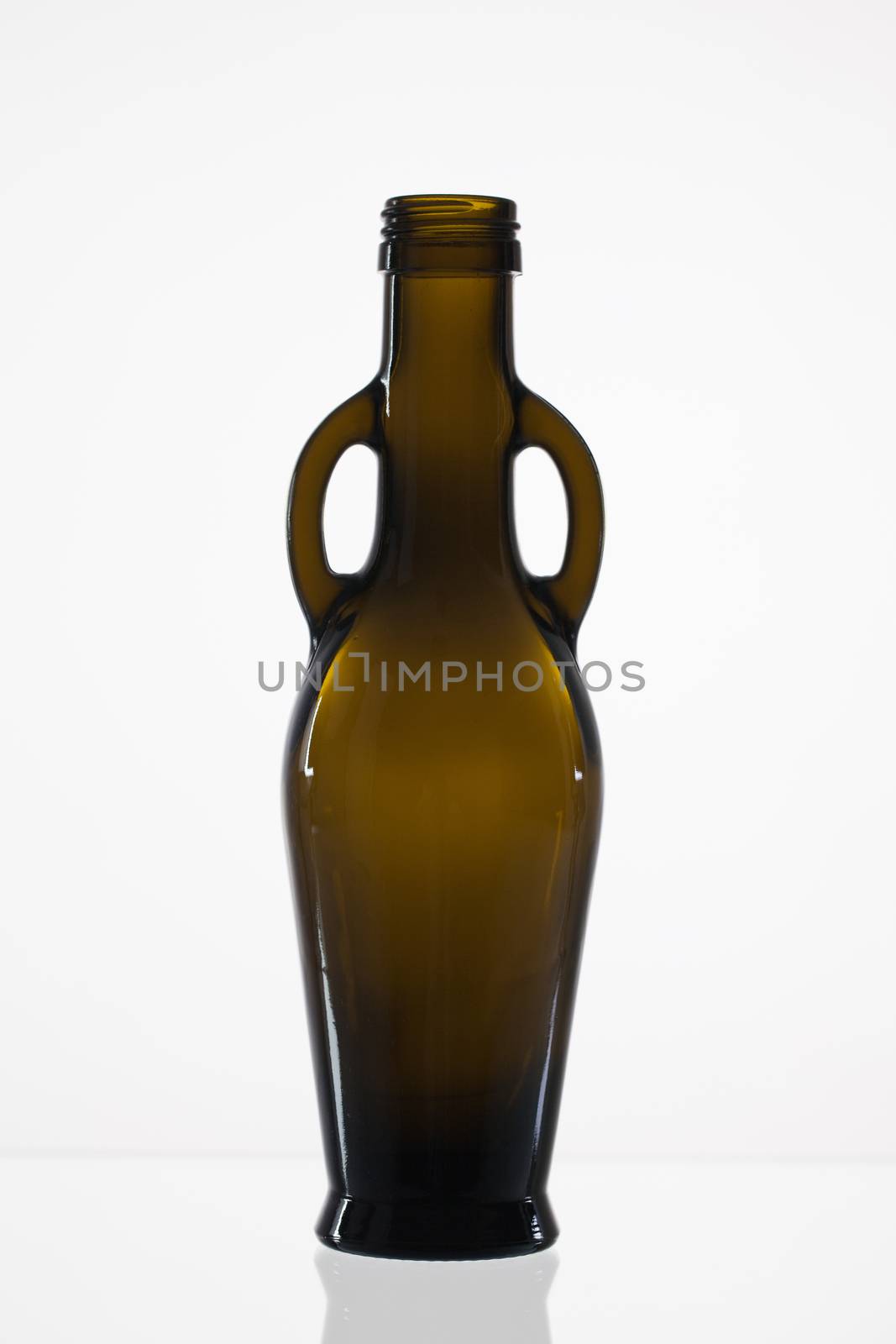 Empty bottle of olive oil on the glass desk