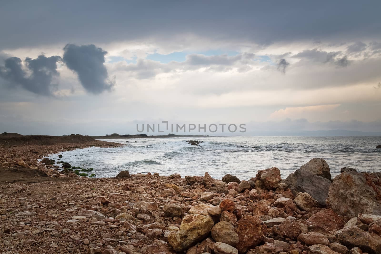 Dark sky, rocky coast and stormy sea by anikasalsera