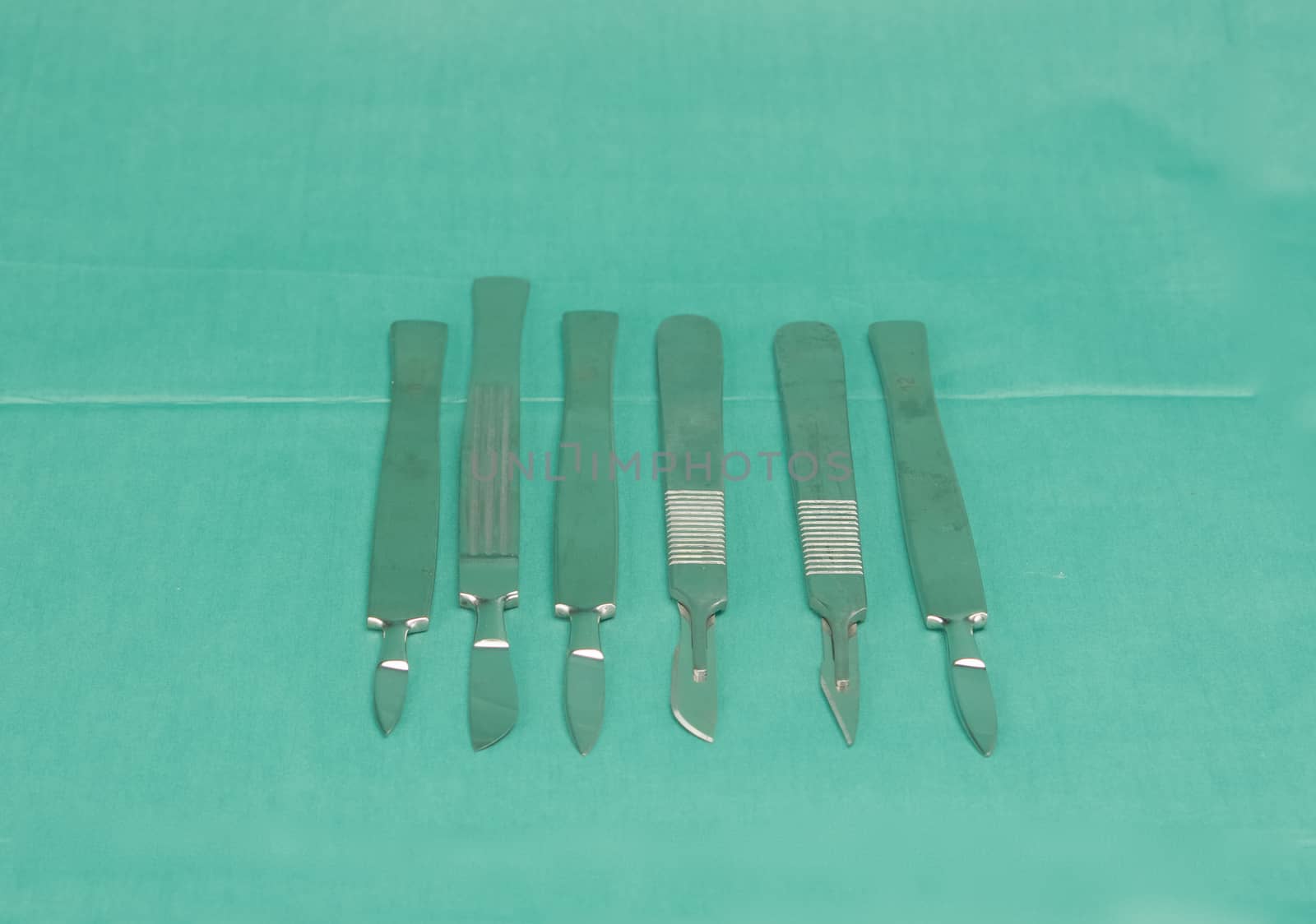 Stainless scalpel on green fabric by ninun