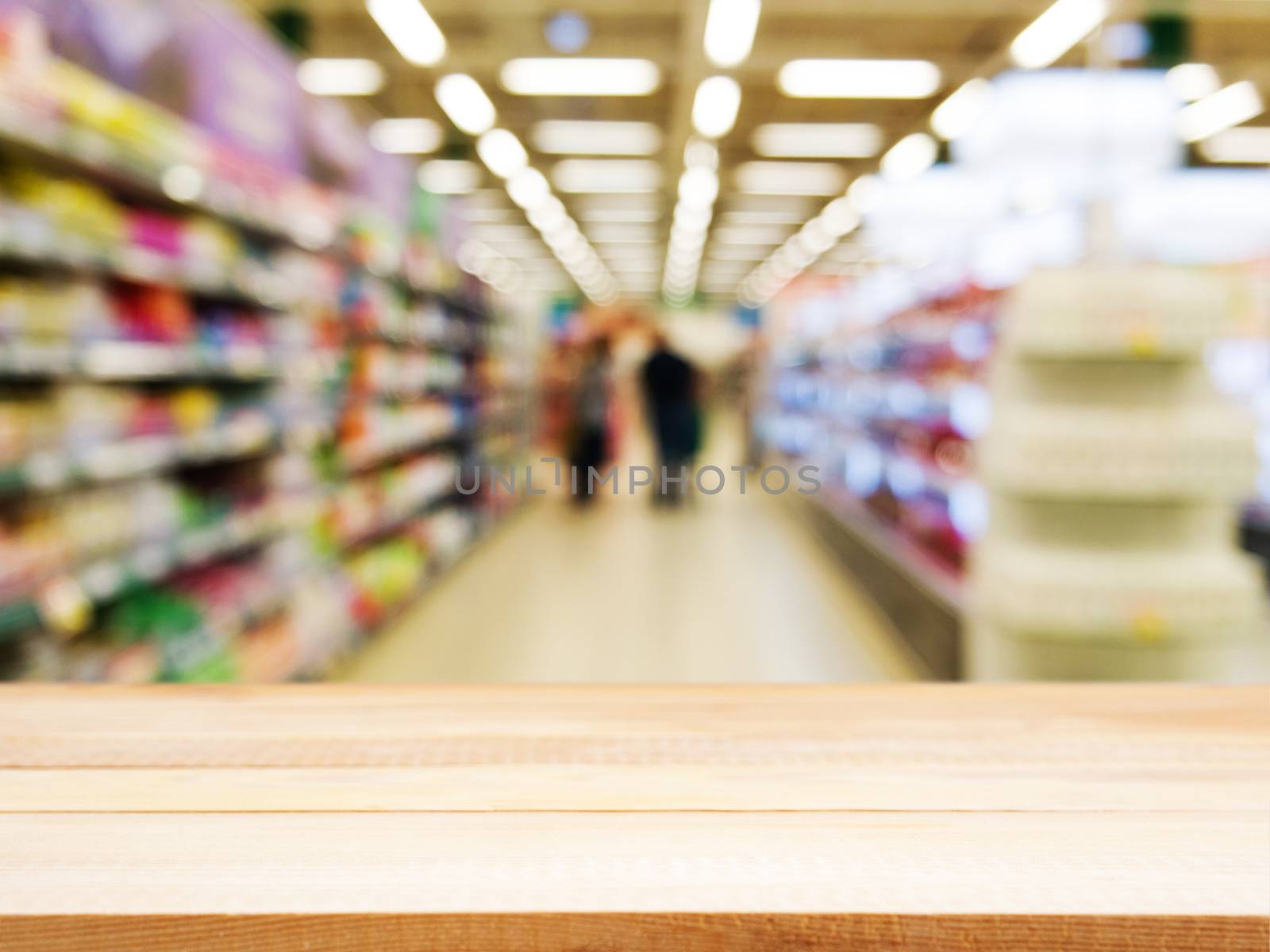 Wooden empty table in front of blurred supermarket by fascinadora