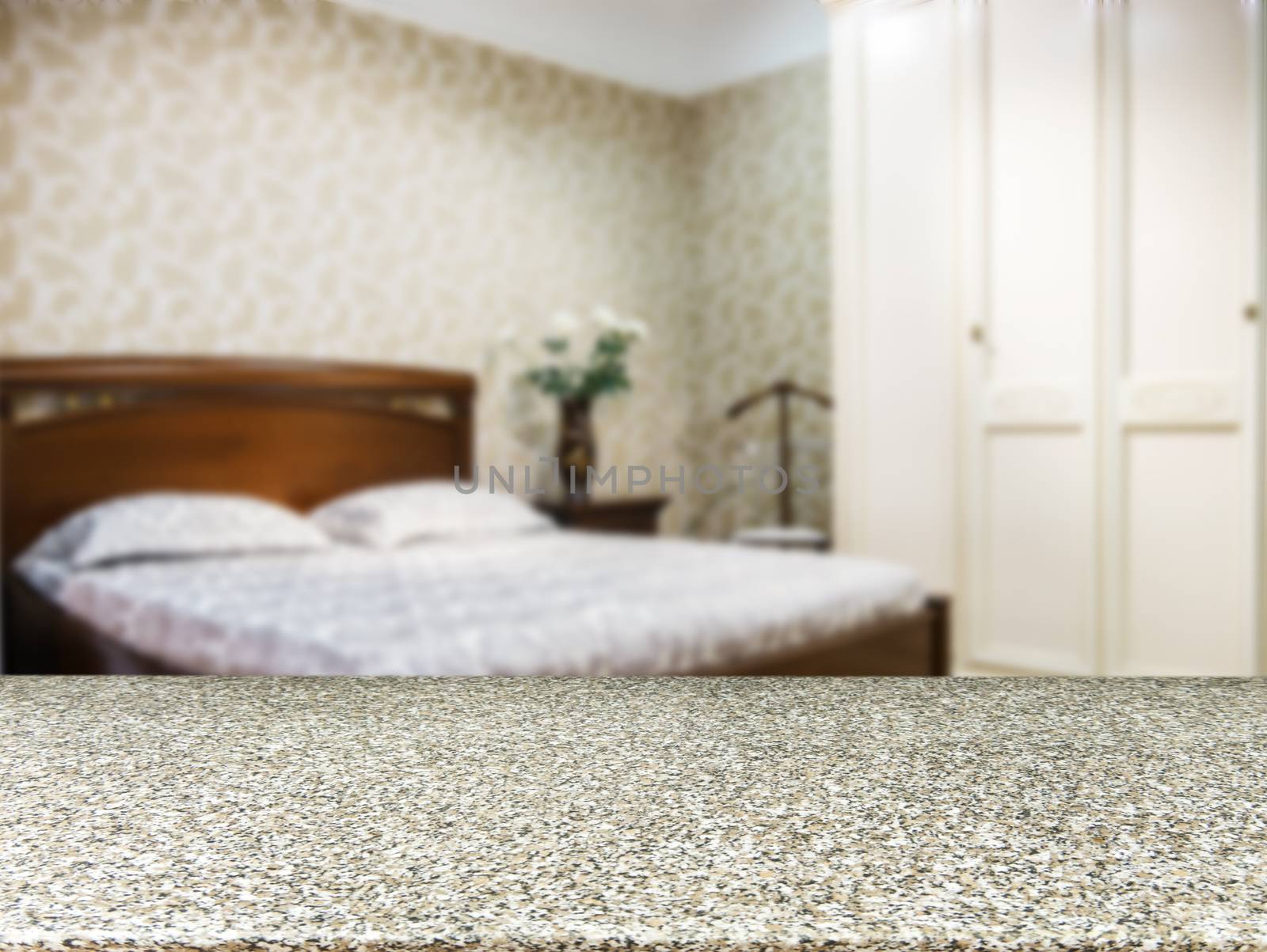 Wooden board empty table in front of blurred background. Perspective marble board over blur in modern bedroom with brown wooden bed. Mock up for display or montage your products