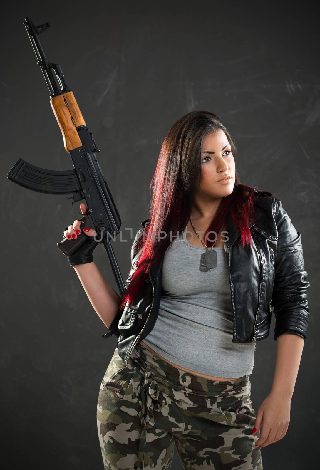 Young beautiful military woman holding rifle