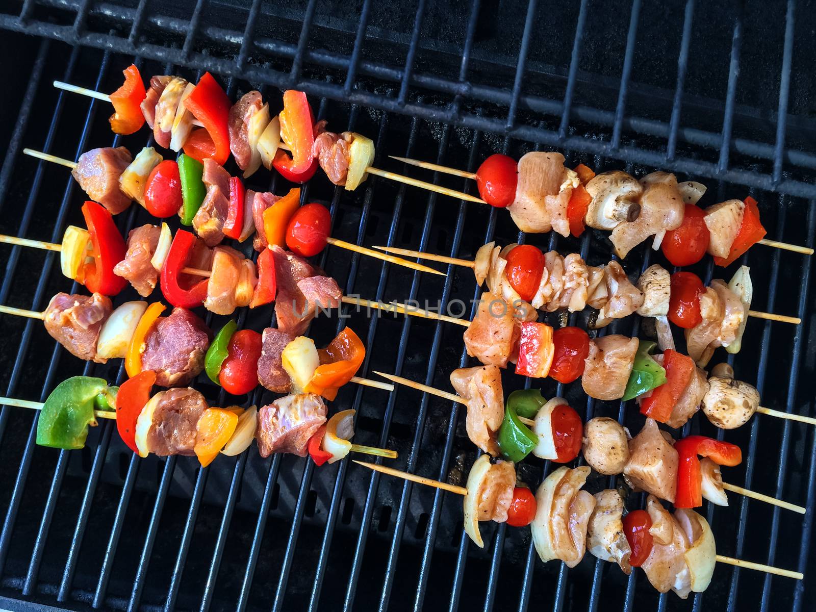 Meat and vegetable skewers on a grill by anikasalsera