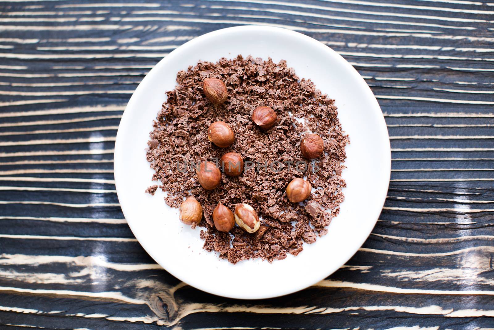 Peanuts splashing into chocolate, slow motion