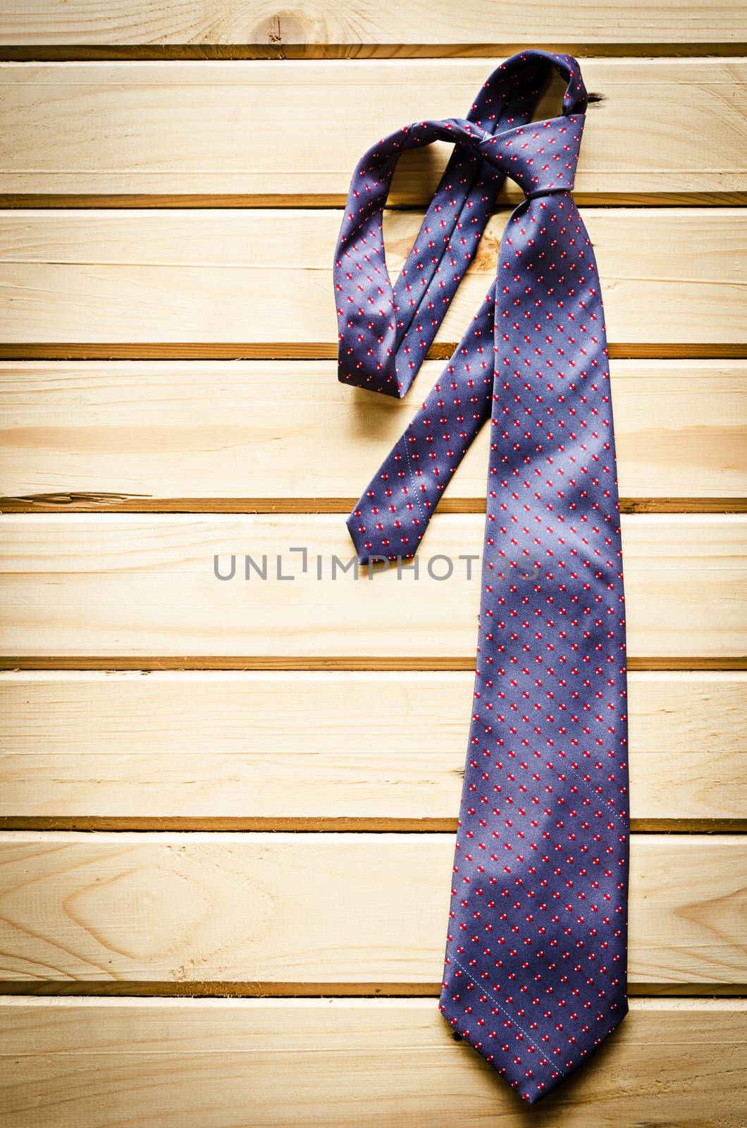 necktie on rustic wood. by Gamjai