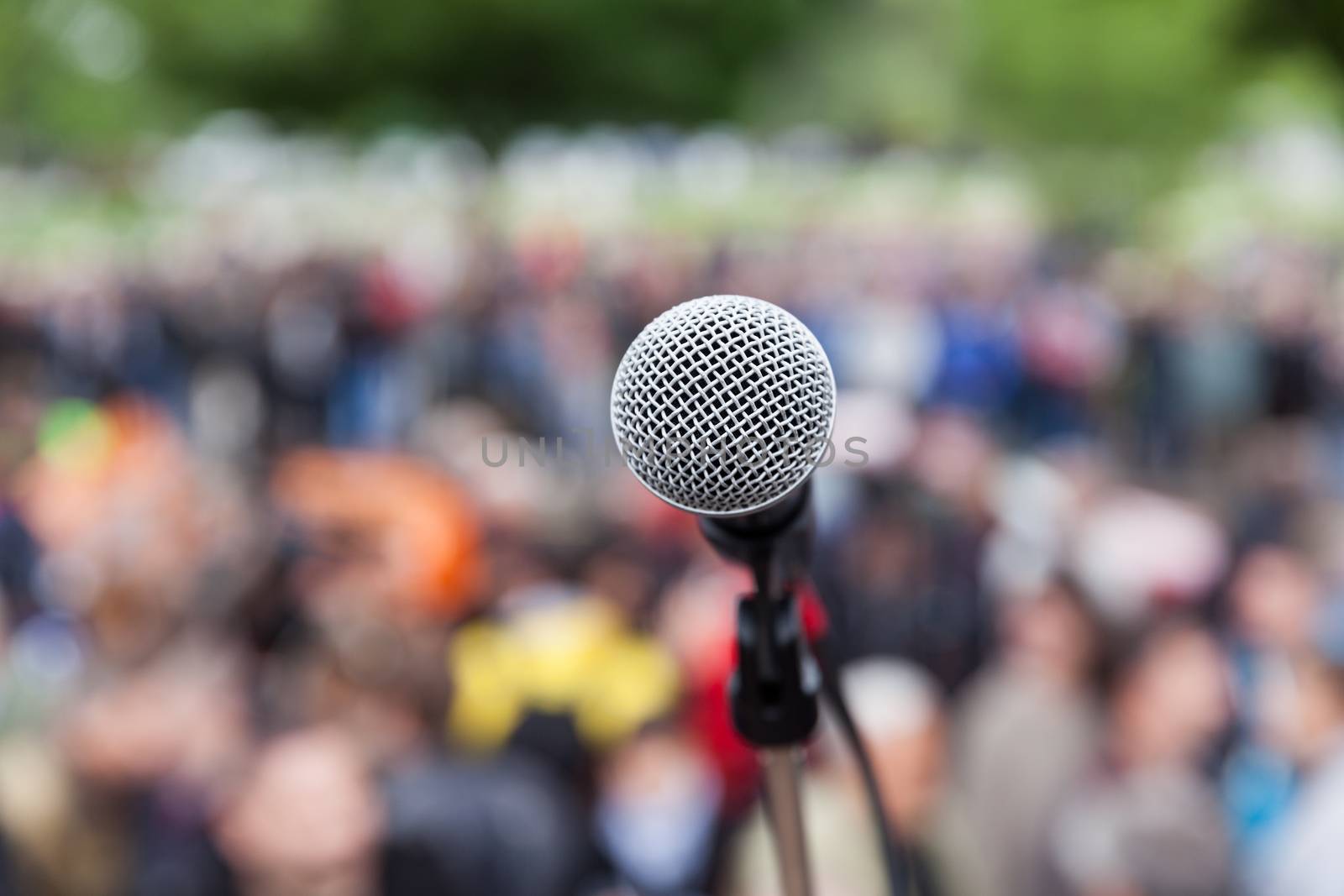 Microphone in focus against blurred audience. Protest. by wellphoto