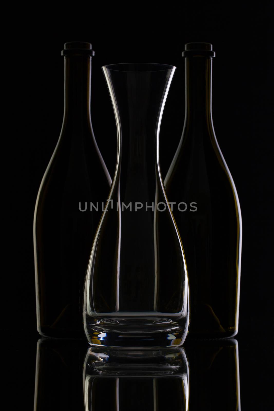 Empty glass and bottles on the black background