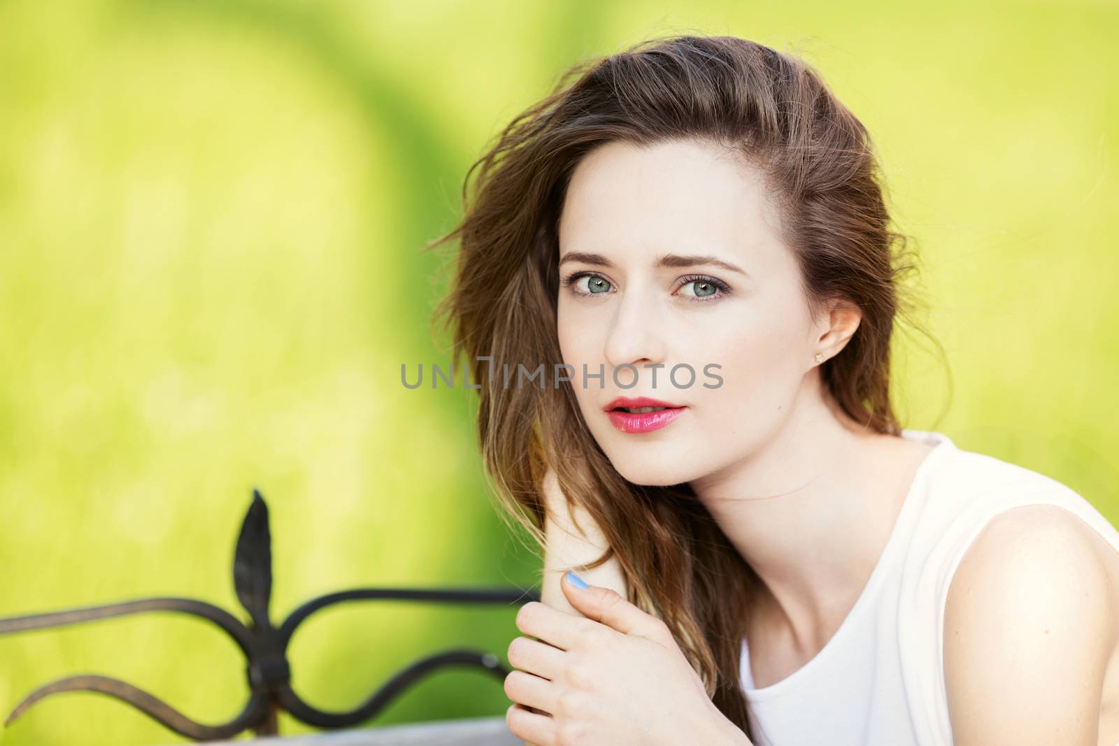 Close up portrait of lovely urban girl outdoors. Portrait of a happy smiling woman. Fashionable blonde girl sitting on a bench in a city park