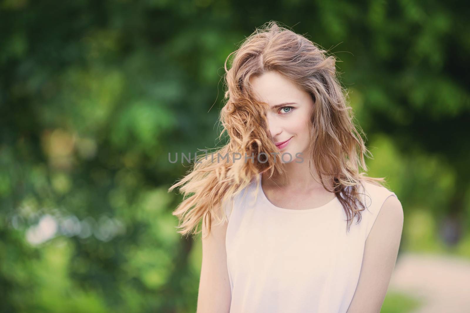 Portrait of lovely urban girl in short white dress in the street. Portrait of a happy smiling woman. Fashionable blonde girl having fun outdoors in the city