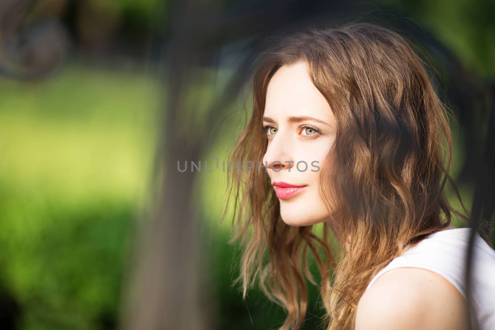 Close up portrait of lovely urban girl outdoors. Portrait of a happy smiling woman. Fashionable blonde girl sitting on a bench in a city park