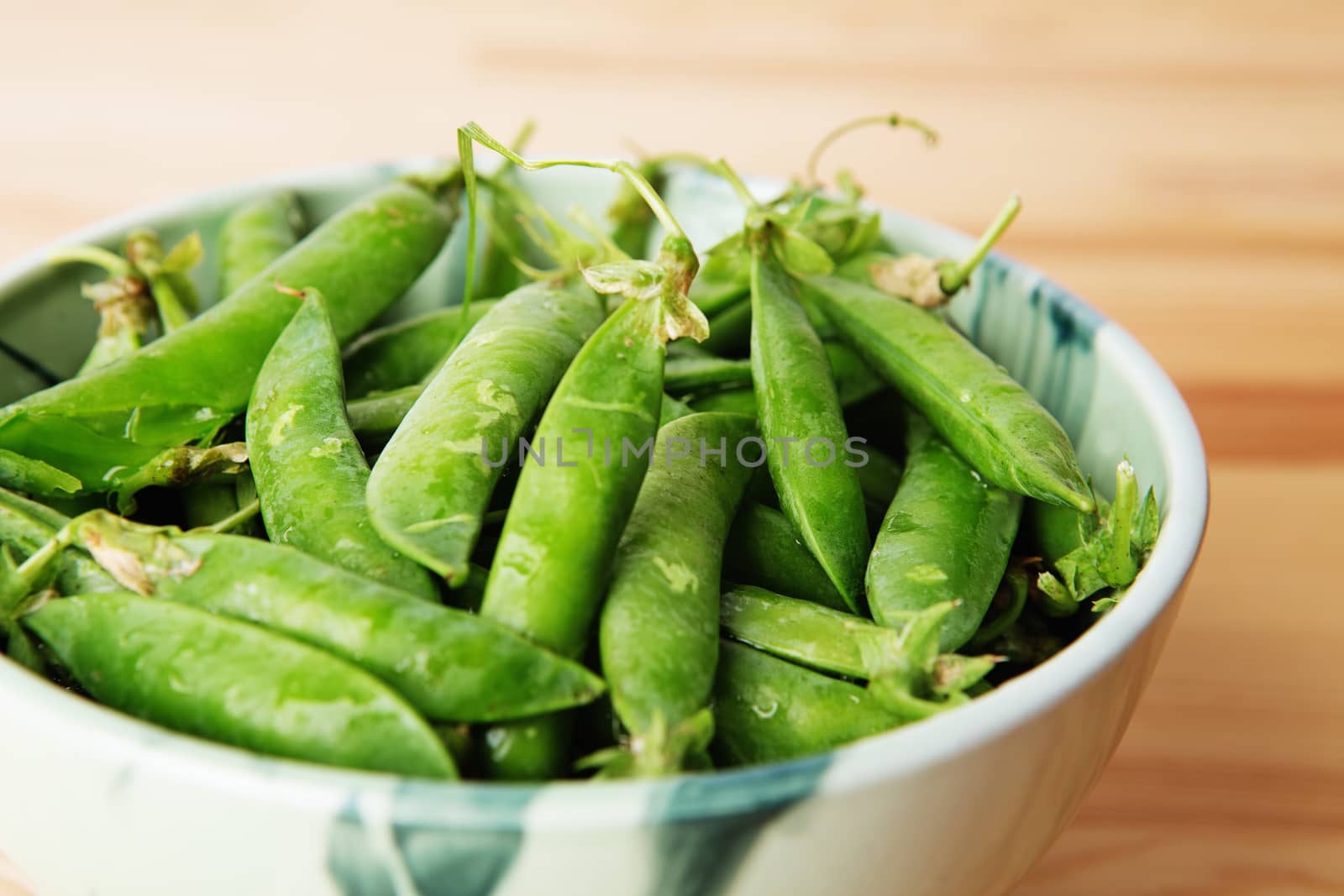 green peas in pods freshly picked on wood. Some green peas. Fresh green peas. green pods with peas as background. Green peas into a bowl