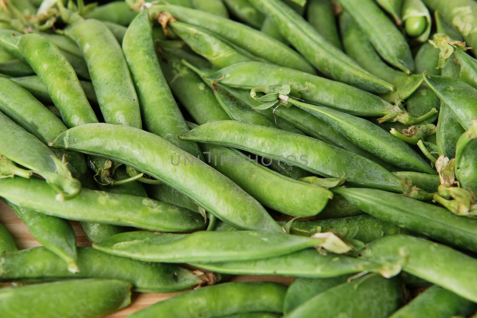 green peas in pods freshly picked on wood. Some green peas. Fresh green peas. green pods with peas as background.