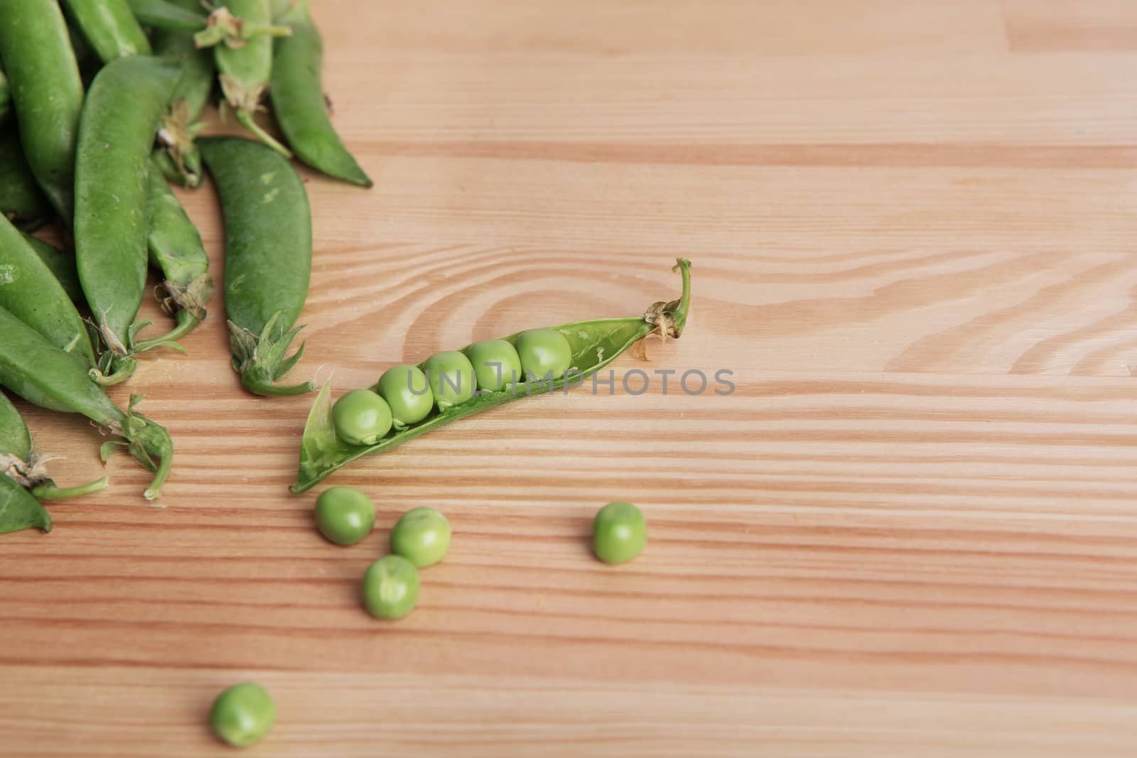 green peas in pods freshly picked on wood. Some green peas. Fresh green peas. green pods with peas as background.