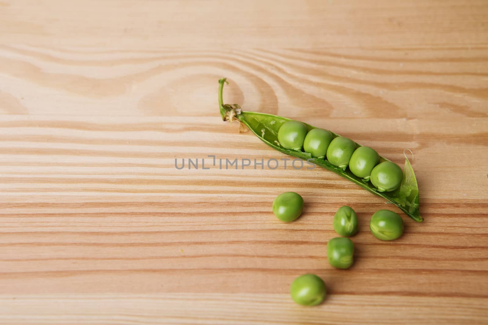 green peas in pods freshly picked on wood. Some green peas. Fresh green peas. green pods with peas as background. Green peas into a bowl