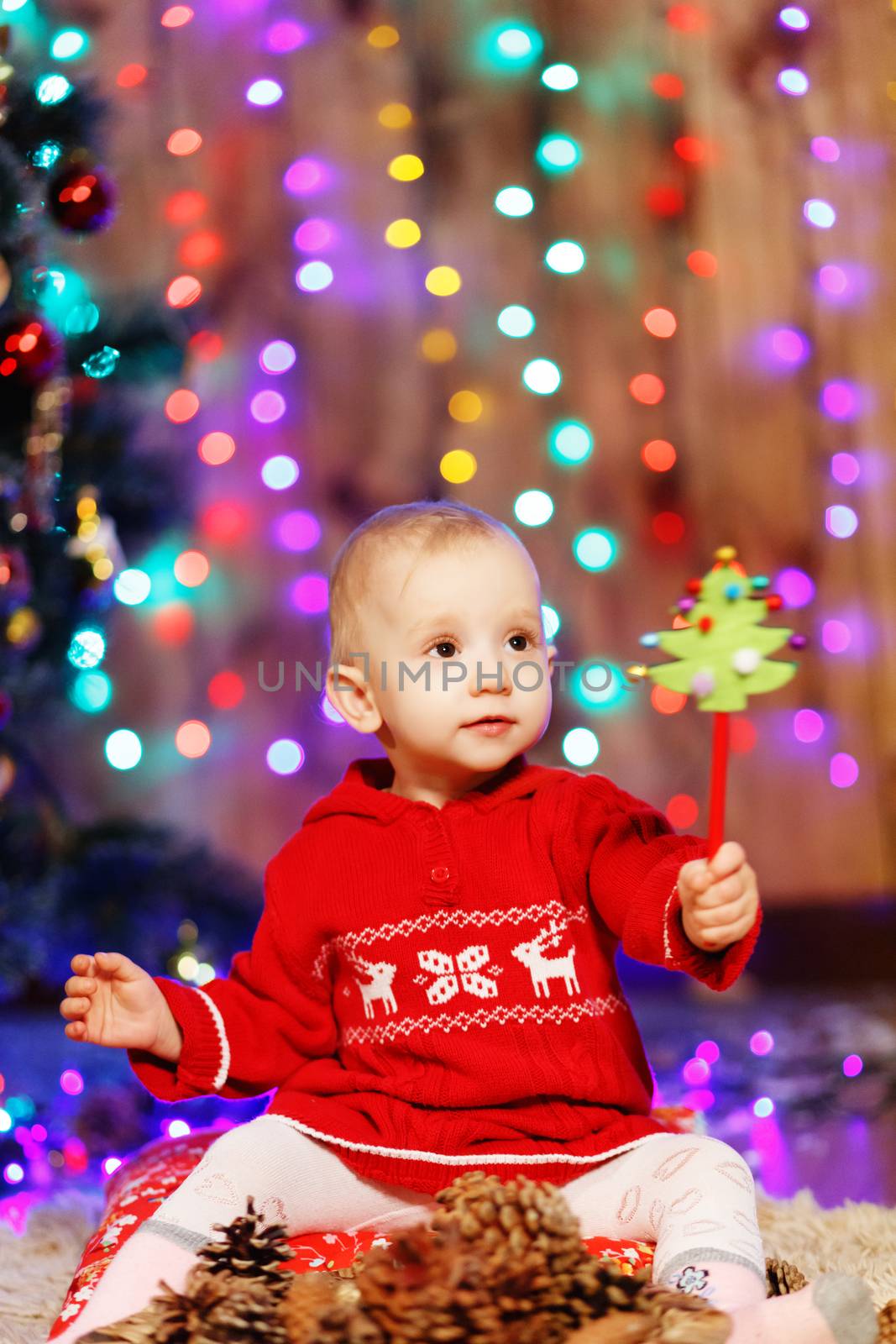 Little baby girl waiting for a miracle in Christmas decorations