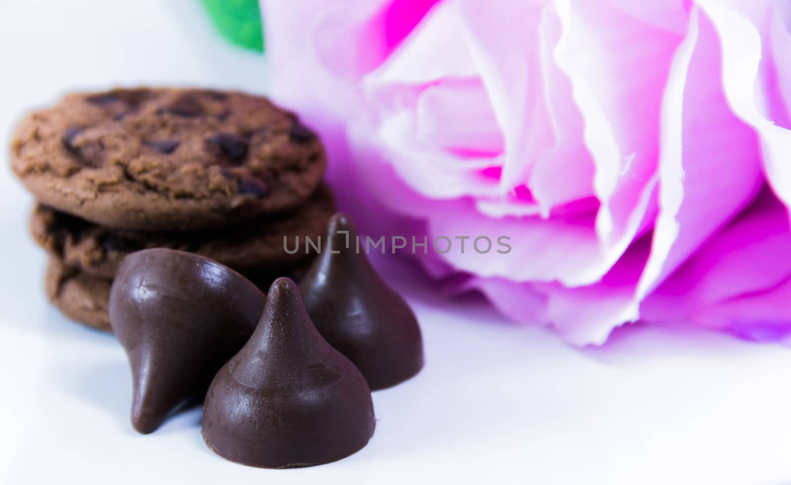 chocolate chip cookies and white rose on pink background by suriyaph