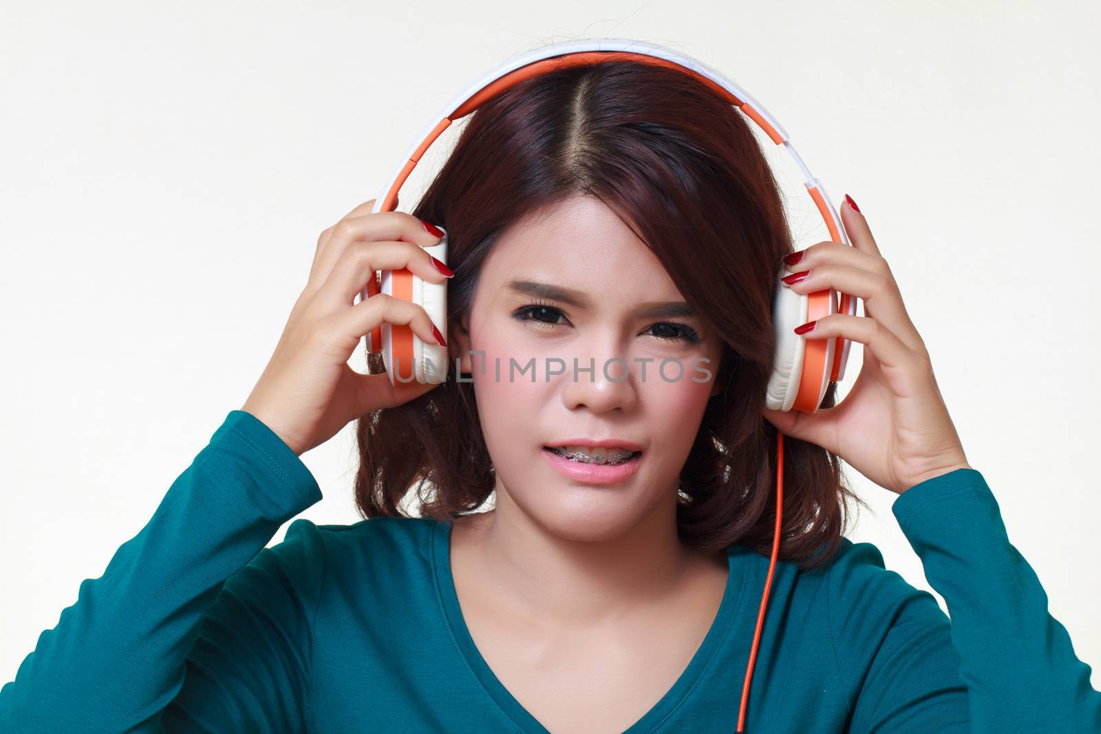 portrait of beautiful young woman with earphones listening a bad music noise